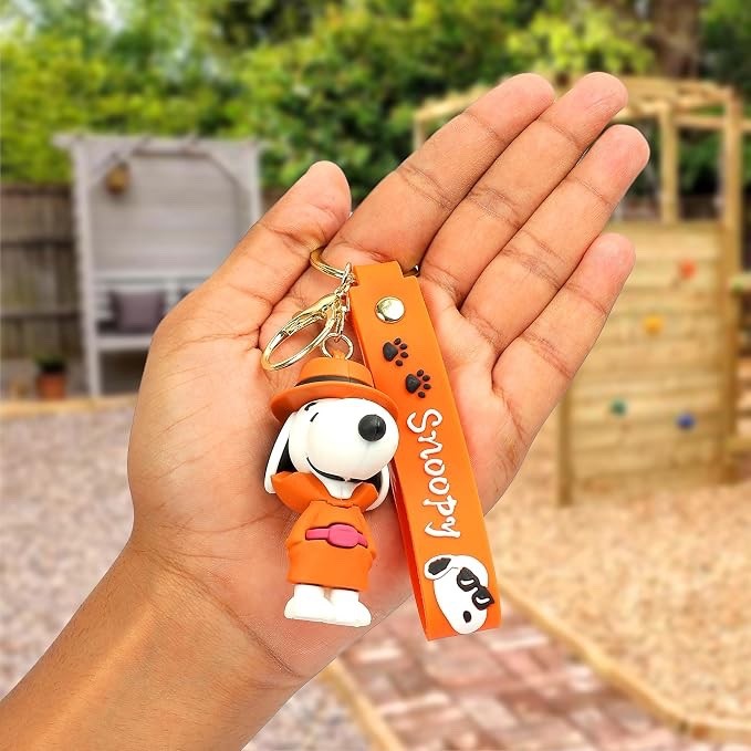 Snoopy orange outfit keychain held outdoors showing full product
