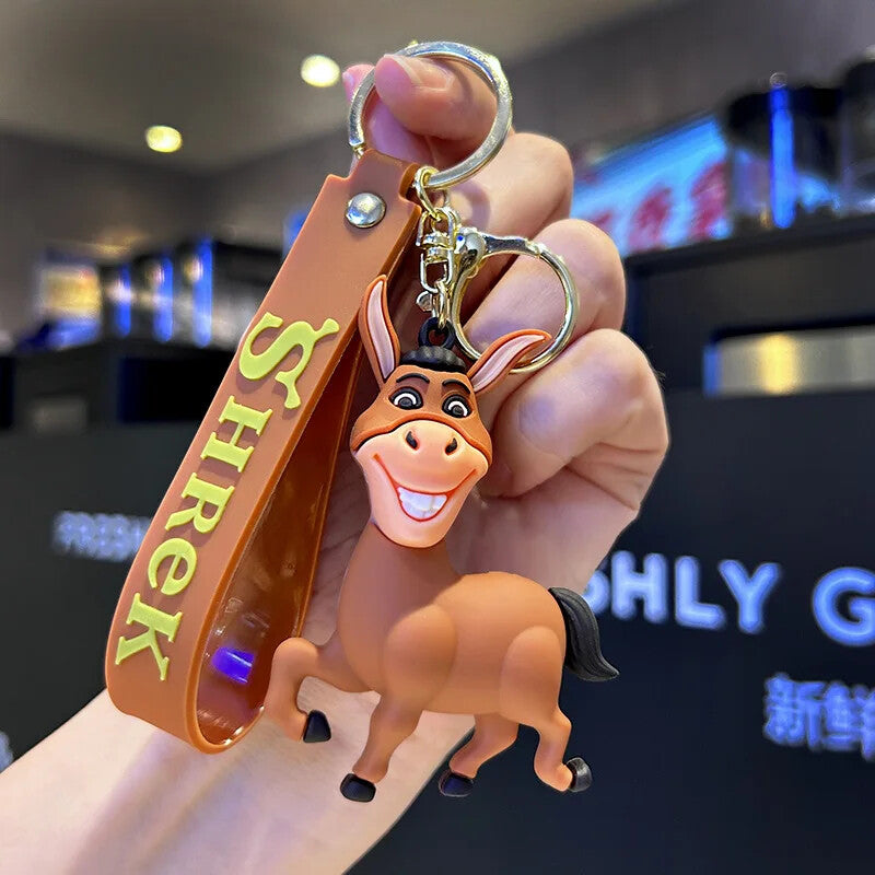 Donkey 3D PVC keychain from Shrek with brown Shrek branded wrist strap, held in hand