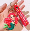 Ariel Little Mermaid 3D PVC keychain with red hair and green tail and red Happy Time wrist strap, held in hand
